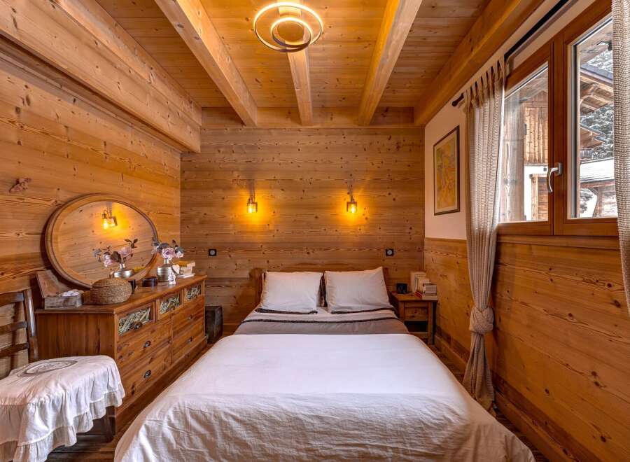 Step into a cozy bedroom retreat, featuring warm wooden paneling and a rustic charm.
