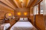 Step into a cozy bedroom retreat, featuring warm wooden paneling and a rustic charm.
