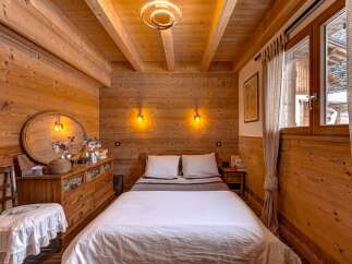 Step into a cozy bedroom retreat, featuring warm wooden paneling and a rustic charm.