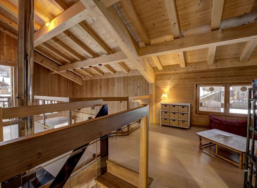 This stunning property boasts a warm and inviting interior with exposed wooden beams and paneling, creating a cozy atmosphere.
