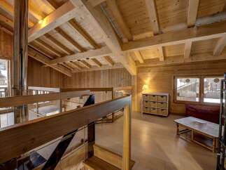 This stunning property boasts a warm and inviting interior with exposed wooden beams and paneling, creating a cozy atmosphere.
