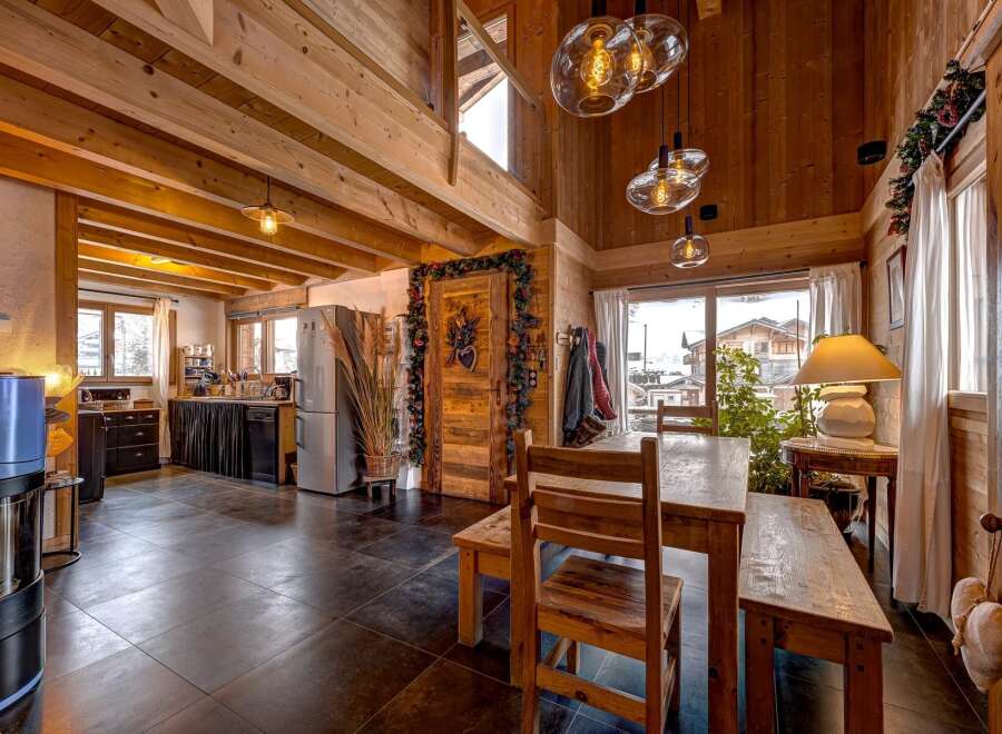 This stunning chalet-style home boasts a warm and inviting interior with exposed wooden beams and a cozy atmosphere.