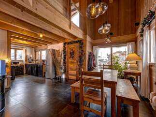 This stunning chalet-style home boasts a warm and inviting interior with exposed wooden beams and a cozy atmosphere.