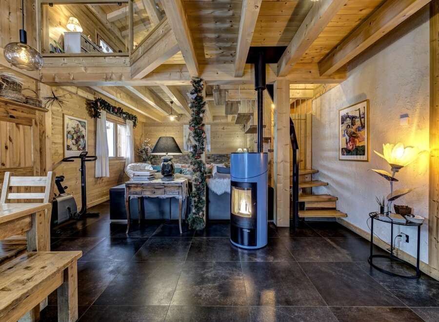 This stunning property features a cozy living space with exposed wooden beams and a modern fireplace, creating a warm and inviting atmosphere.