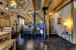 This stunning property features a cozy living space with exposed wooden beams and a modern fireplace, creating a warm and inviting atmosphere.