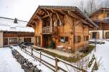 This stunning wooden chalet offers a cozy retreat in a snowy landscape.
