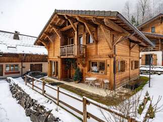 This stunning wooden chalet offers a cozy retreat in a snowy landscape.