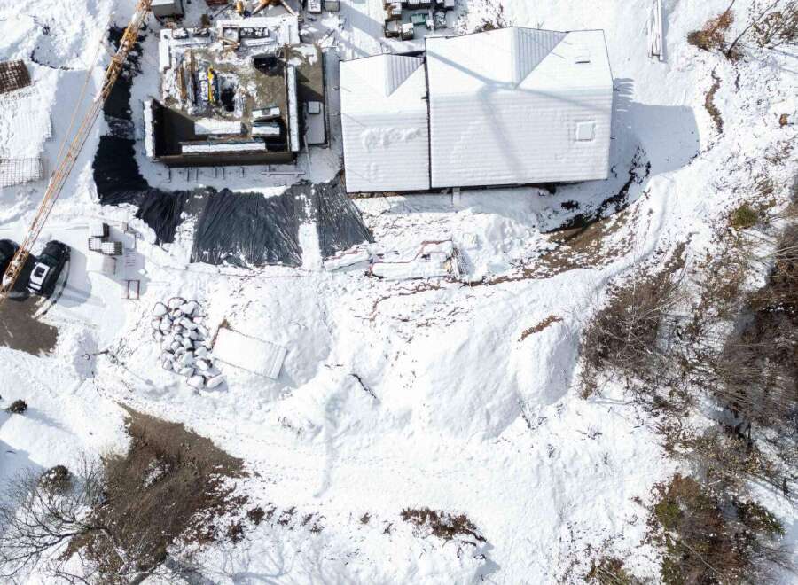 This stunning property boasts a modern design with a snow-covered roof, offering a unique aesthetic.