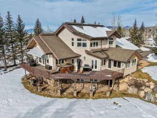 This stunning property boasts a multi-level deck, perfect for enjoying the mountain views.