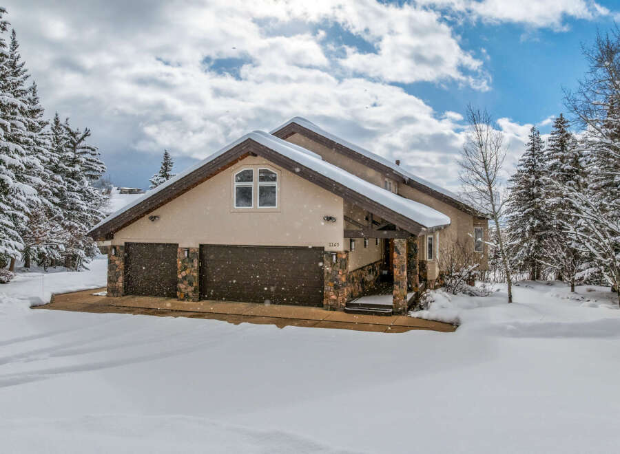 This stunning property boasts a beautiful exterior with a snow-covered roof and surrounding landscape.