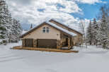 This stunning property boasts a beautiful exterior with a snow-covered roof and surrounding landscape.