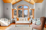 Step into luxury with this stunning living room, boasting a vaulted wooden ceiling and expansive windows that frame breathtaking views.