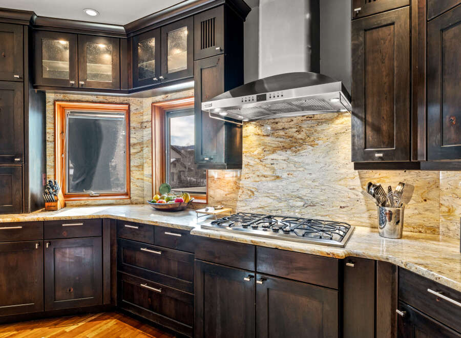 This stunning kitchen boasts dark wood cabinetry, creating a warm and inviting atmosphere.