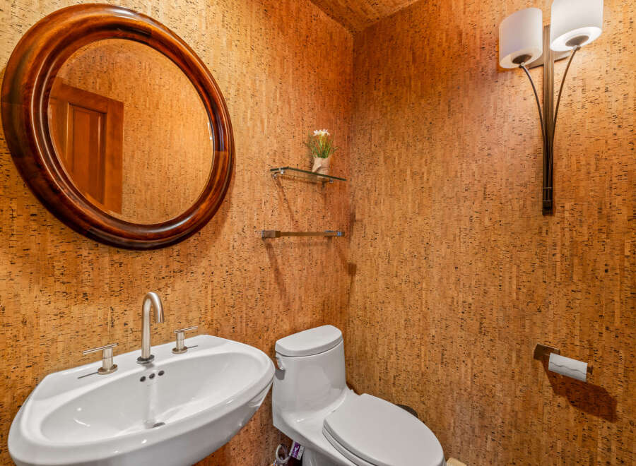 This stunning powder room showcases a unique cork wall design, creating a warm and inviting atmosphere.