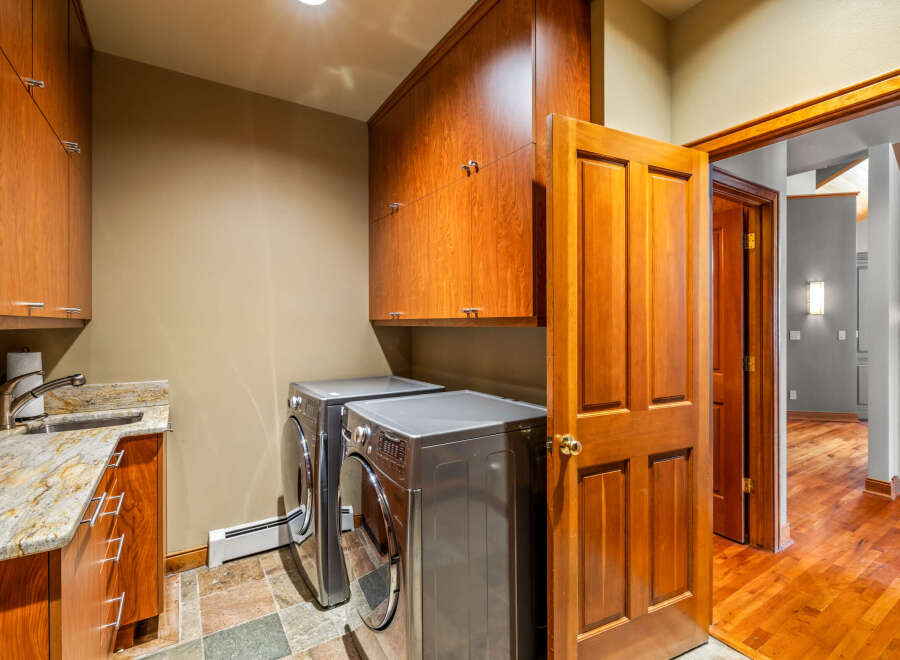This stunning laundry room boasts custom cabinetry and modern appliances, creating a functional and stylish space.