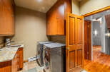 This stunning laundry room boasts custom cabinetry and modern appliances, creating a functional and stylish space.