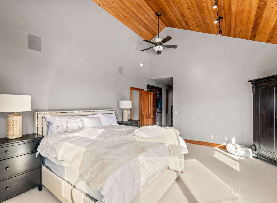 Step into luxury with this stunning bedroom featuring a vaulted wood ceiling and ample natural light.