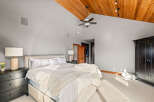 Step into luxury with this stunning bedroom featuring a vaulted wood ceiling and ample natural light.
