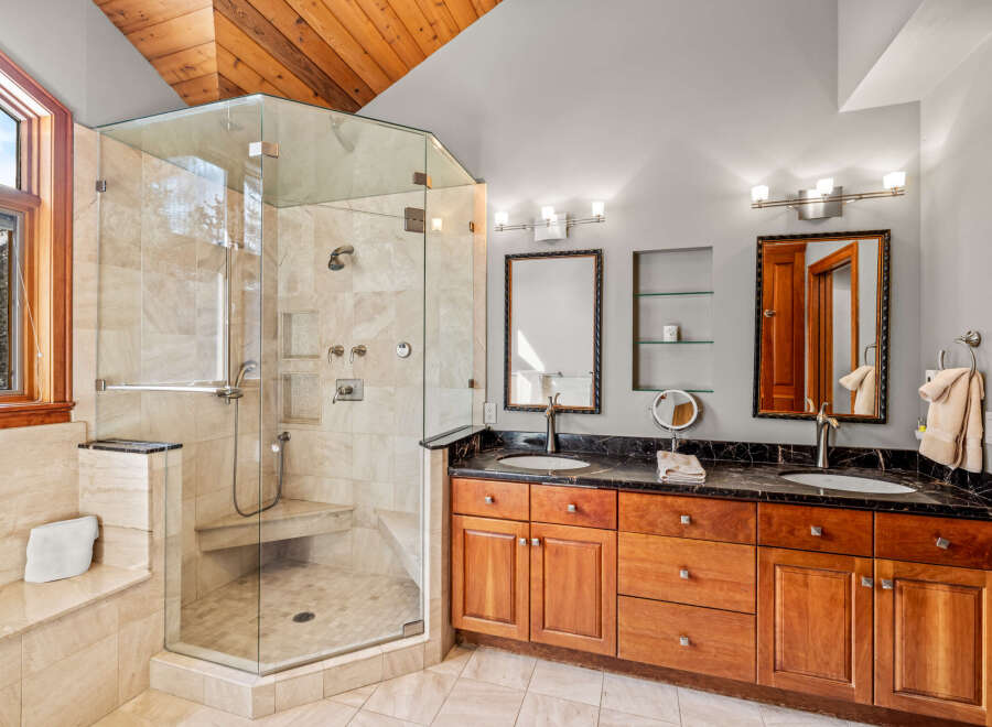 Step into luxury with this stunning bathroom featuring a spacious glass-enclosed shower and elegant double vanity.