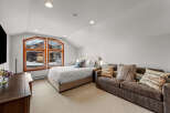 This cozy bedroom features a comfortable bed, a stylish sofa, and a large window that offers stunning views.