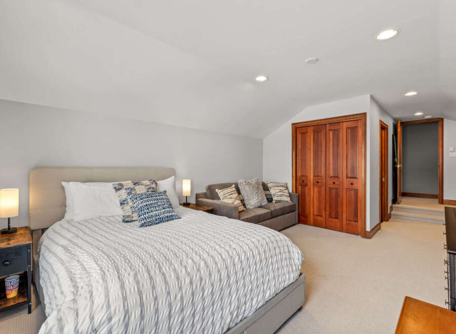 This spacious bedroom features a comfortable bed with stylish bedding and decorative pillows.