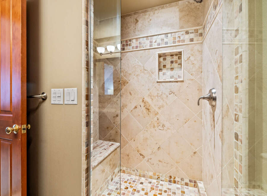 Step into luxury with this stunning bathroom featuring a beautifully tiled shower.
