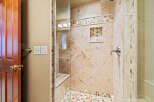 Step into luxury with this stunning bathroom featuring a beautifully tiled shower.