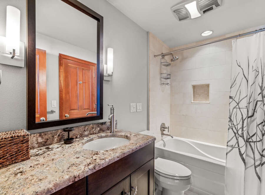 This stunning bathroom features a modern design with a sleek vanity and a beautiful granite countertop.