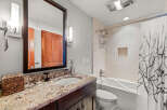 This stunning bathroom features a modern design with a sleek vanity and a beautiful granite countertop.