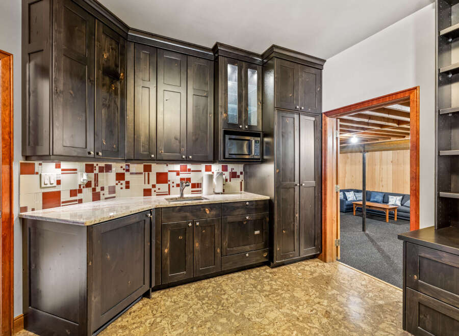 This stunning kitchen boasts custom dark wood cabinetry, offering ample storage and a sophisticated aesthetic.
