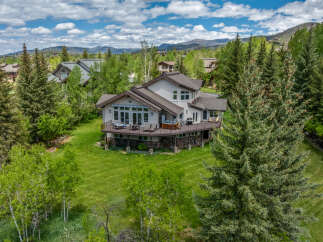 Experience luxury mountain living in this stunning home, nestled amidst lush greenery and mature trees.