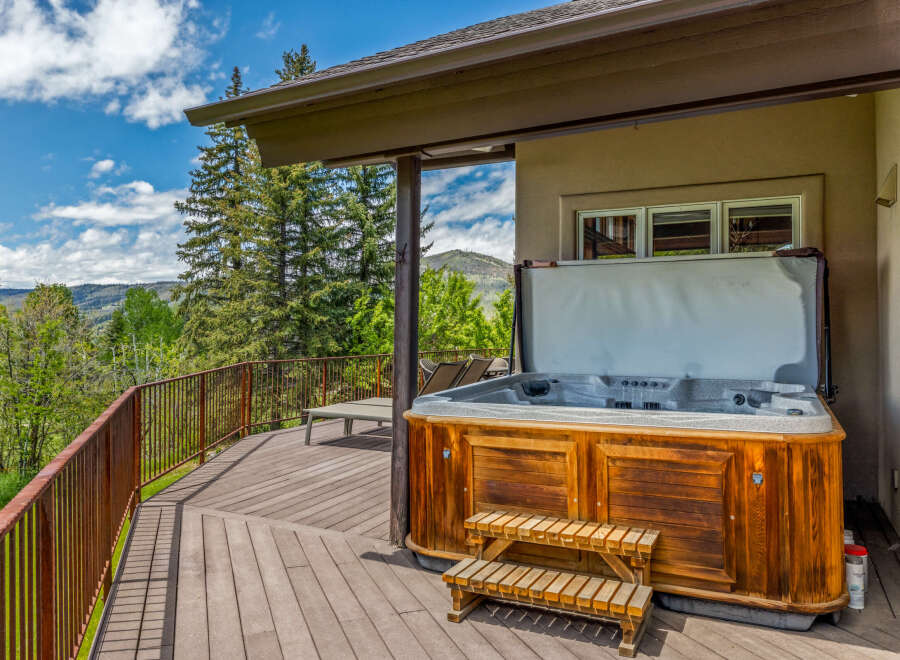 Experience ultimate relaxation on this expansive deck, featuring a luxurious hot tub with stunning mountain views.