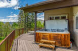 Experience ultimate relaxation on this expansive deck, featuring a luxurious hot tub with stunning mountain views.