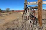 Discover the charm of this rustic property, featuring a weathered wagon wheel and a classic wooden fence.