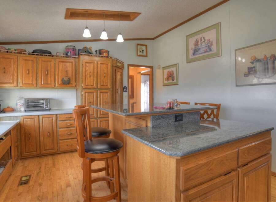 This charming kitchen boasts beautiful wooden cabinetry, offering ample storage and a warm, inviting atmosphere.