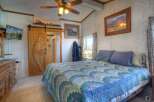 This charming bedroom features a rustic sliding barn door leading to a private bathroom.