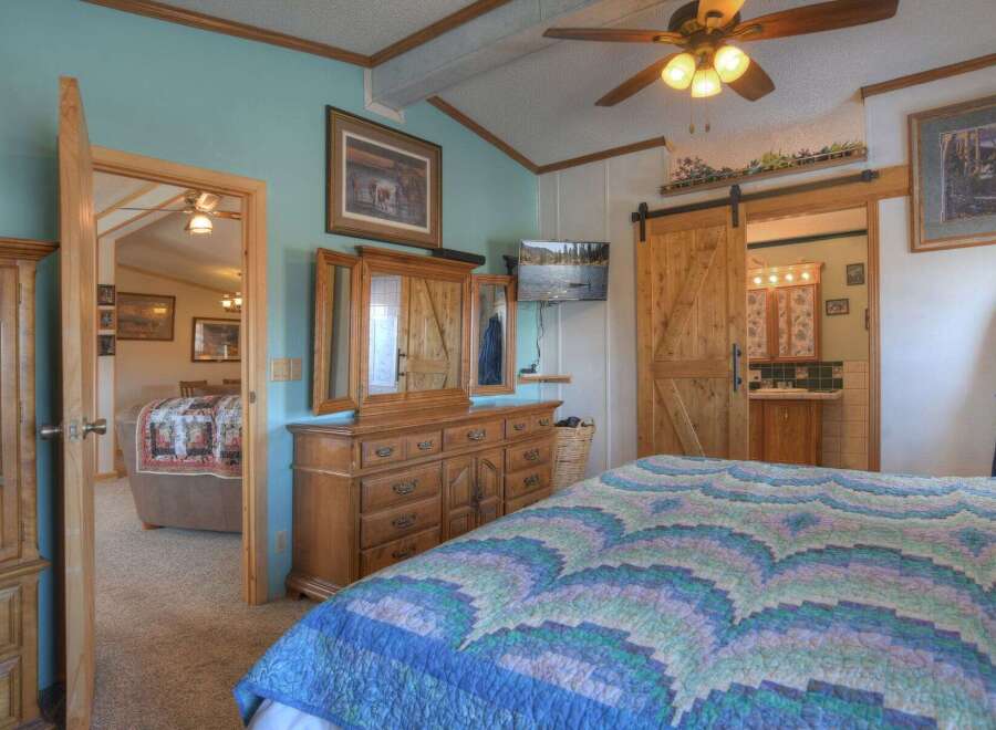 Step into this inviting bedroom, featuring a cozy bed adorned with a beautiful quilt.