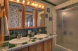 This charming bathroom features a double vanity with a unique tile countertop and matching backsplash, offering ample space and style.