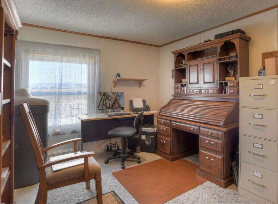 Step into this inviting home office, featuring a classic roll-top desk and ample storage.