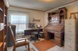 Step into this inviting home office, featuring a classic roll-top desk and ample storage.