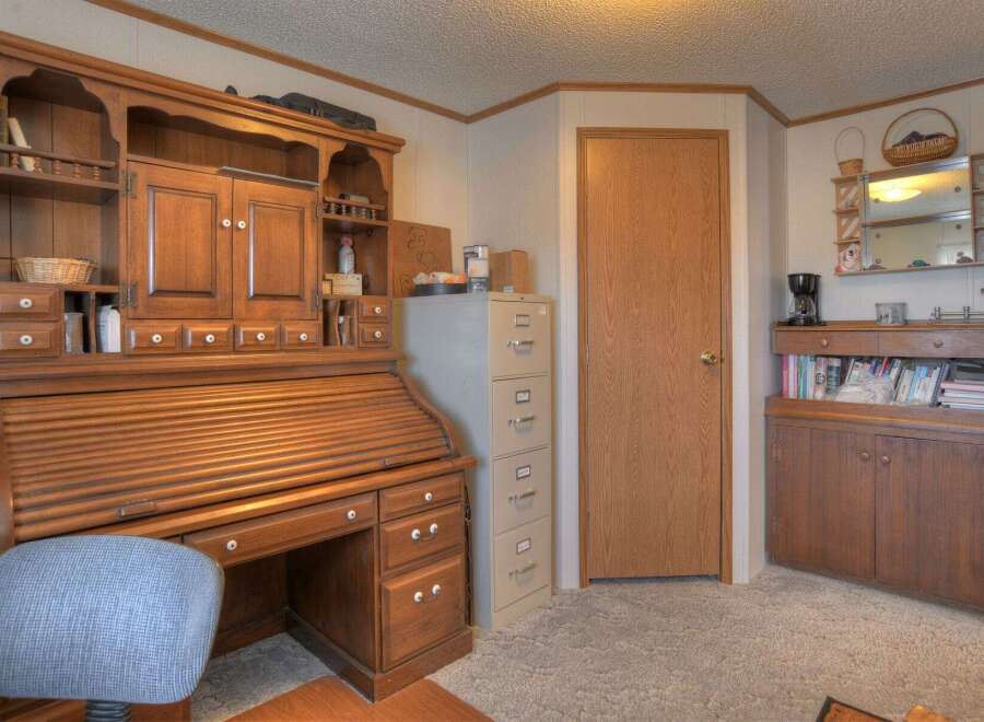 This charming property boasts a beautifully crafted wooden desk with ample storage, perfect for a home office or creative space.