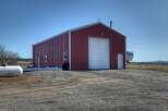This property features a spacious red metal building, perfect for storage or a workshop.