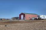 This property offers a spacious red barn with a green roof, perfect for storage or a workshop.