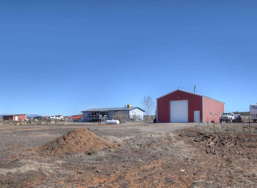 Discover the charm of this spacious property, featuring a well-maintained home and a large red barn, perfect for storage or hobbies.
