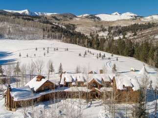 Nestled in a winter wonderland, this stunning property boasts a luxurious log cabin design, perfect for those seeking a mountain retreat.