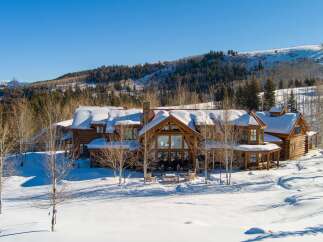 Experience luxury living in this stunning log cabin nestled in a winter wonderland.