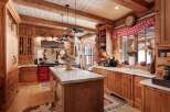 Step into rustic elegance with this stunning kitchen! Featuring custom wood cabinetry, a marble-topped island, and a vibrant red stove, this space is perfect for both cooking and entertaining.