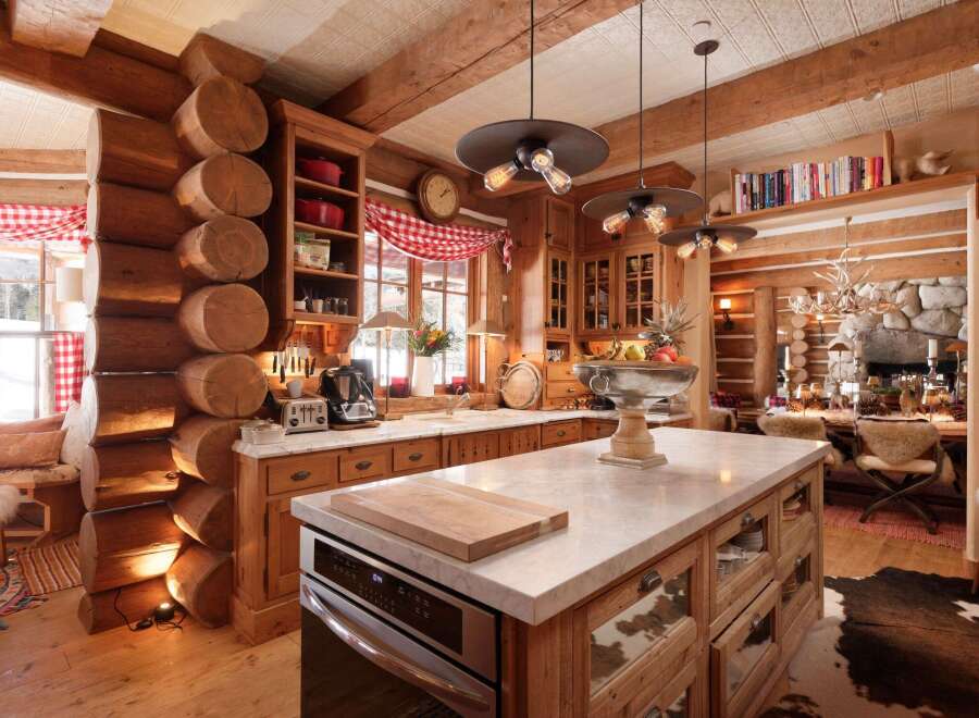 This stunning kitchen showcases rustic elegance with its log cabin design and modern amenities.