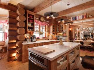This stunning kitchen showcases rustic elegance with its log cabin design and modern amenities.