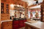 This stunning kitchen showcases a rustic charm with its wooden cabinetry and a striking red AGA stove.